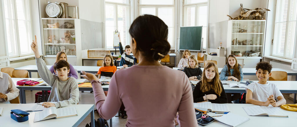 Eine Lehrerin steht vor einer Klasse