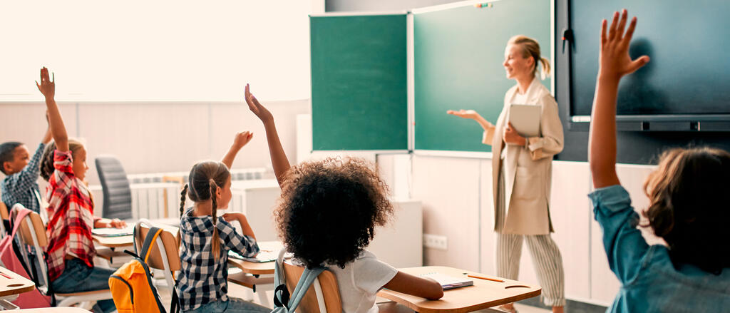 Eine junge Lehrkraft steht vor ihrer Klasse