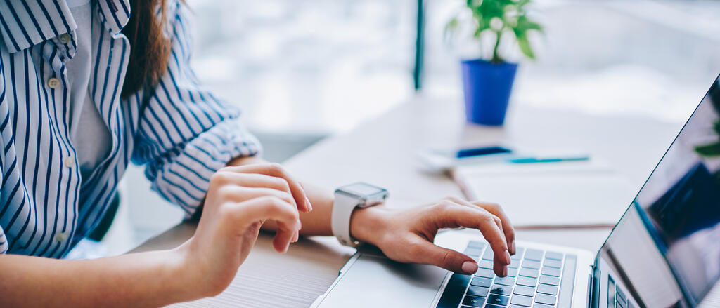 Eine Frau versendet eine digitale Bewerbung am Computer